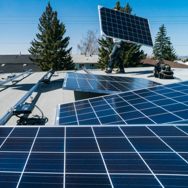 Worker installing solar panels on a residential homes roof.